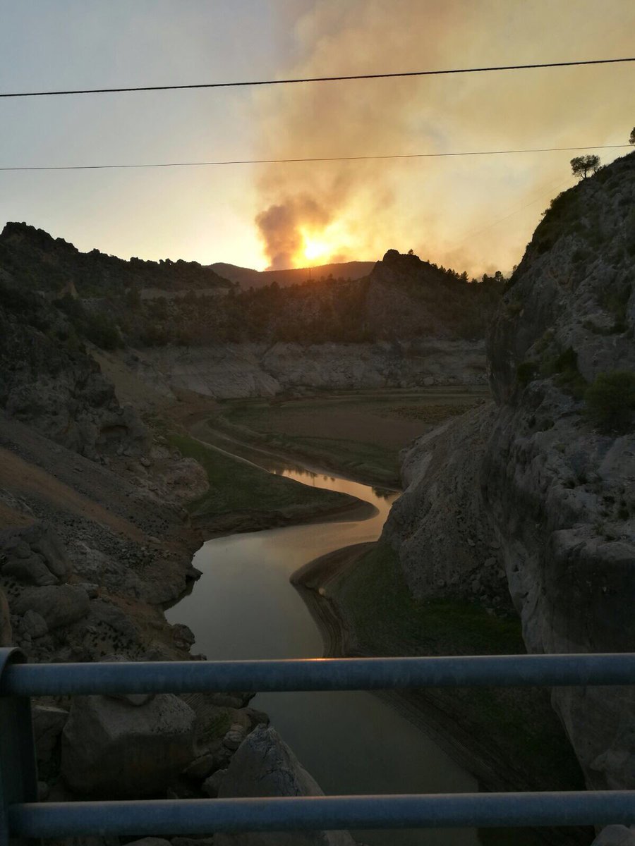 El embalse de La Fuensanta con la columna de humo del incendio de Yeste en el fondo