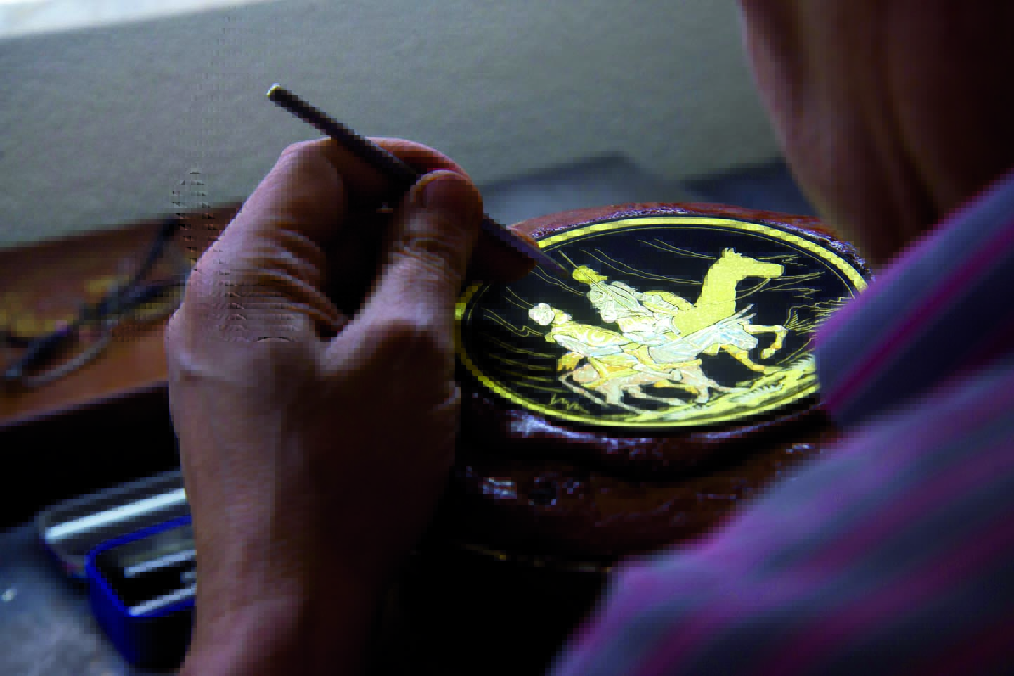Imagen de un artesano realizando un damasquinado.