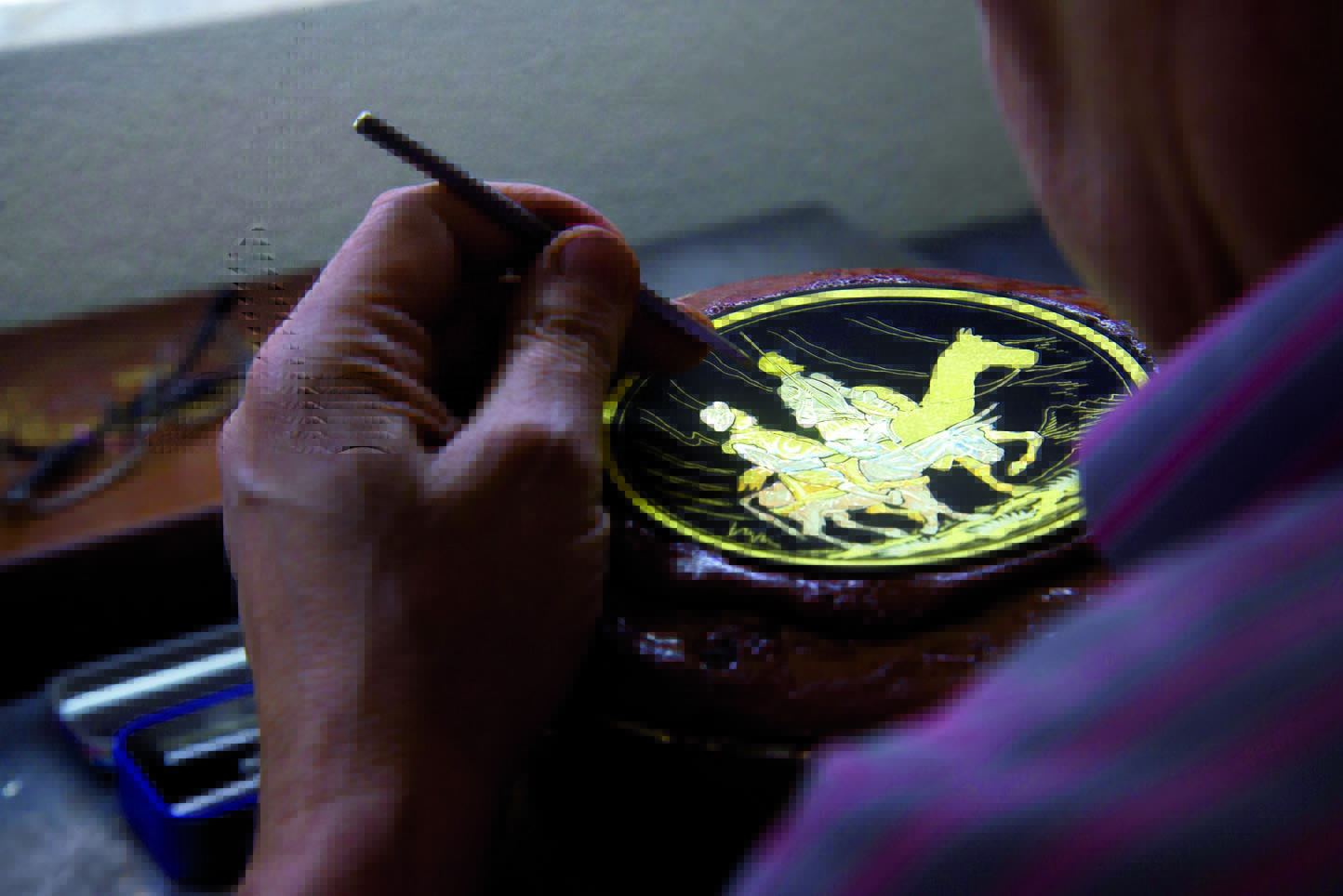 Imagen de un artesano realizando un damasquinado.
