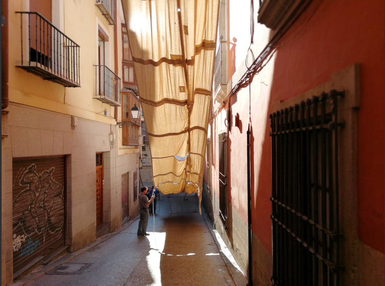 Un trabajador retira los últimos toldos del Corpus de la calle Trinidad, en Toledo.