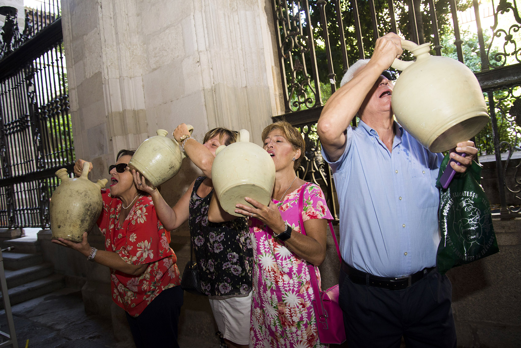 Varias personas beben de los botijos con agua de la Virgen en la Catedral de Toledo. botijos