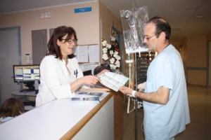 Imagen de archivo de una enfermera mostrando un folleto informativo a un paciente. Listas de espera