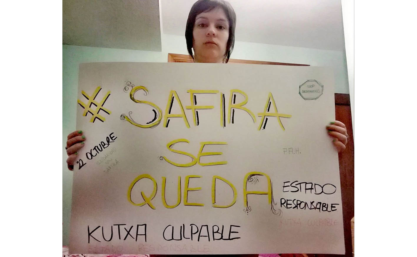 Safira con un cartel con el hashtag que pide que se quede en su casa. desahucio