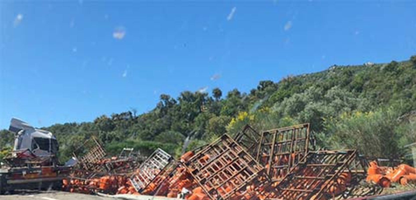 Las bombonas de butano han quedado esparcidas por la carretera, que ha tenido que ser cortada al tráfico.