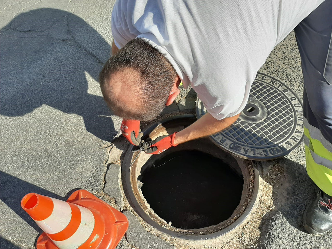 Un trabajador coloca raticida en una de las alcantarillas de Quintanar de la Orden.