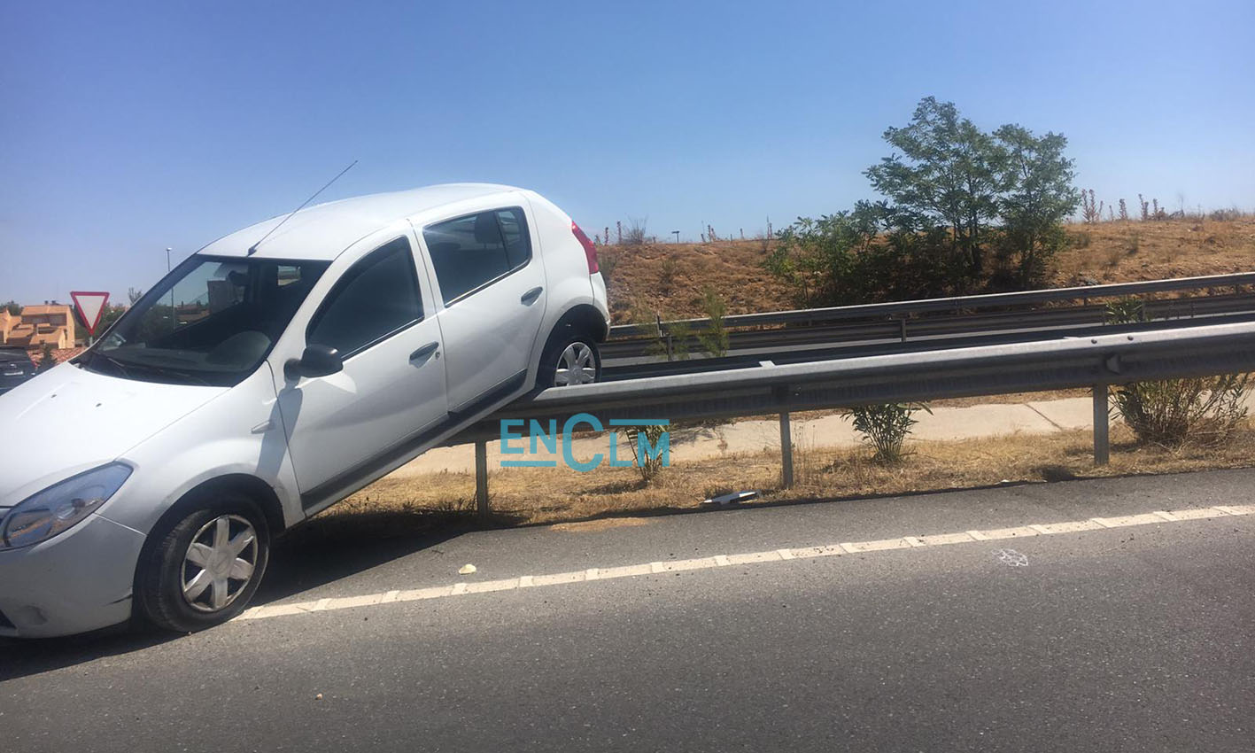 Medio coche quedó encima del quitamiedos de una rotonda en Toledo.