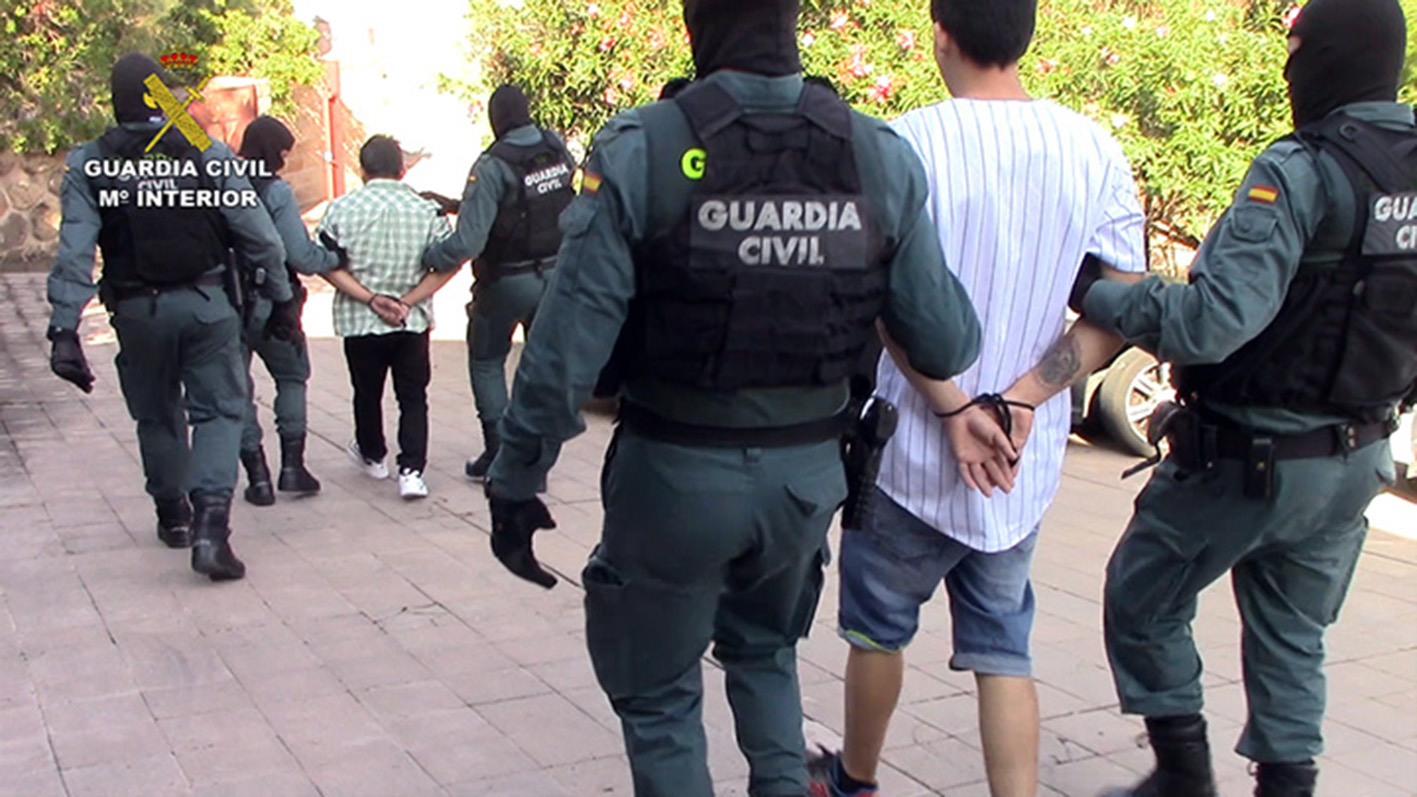 Los dos detenidos, camino de cuartel de la Guardia Civil escoltados por varios agentes.