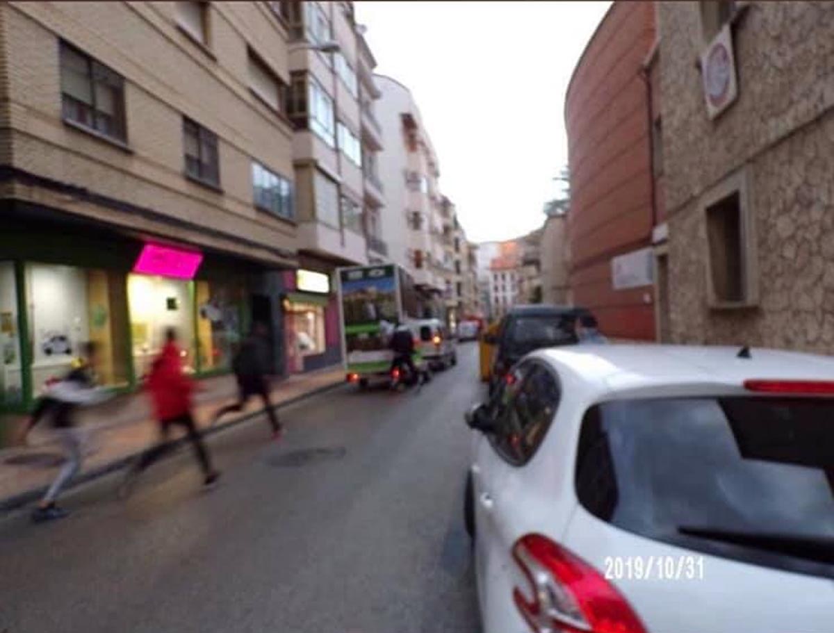 Momento en el que unos jóvenes persiguen y golpean el vehículo de propaganda de Vox en Cuenca