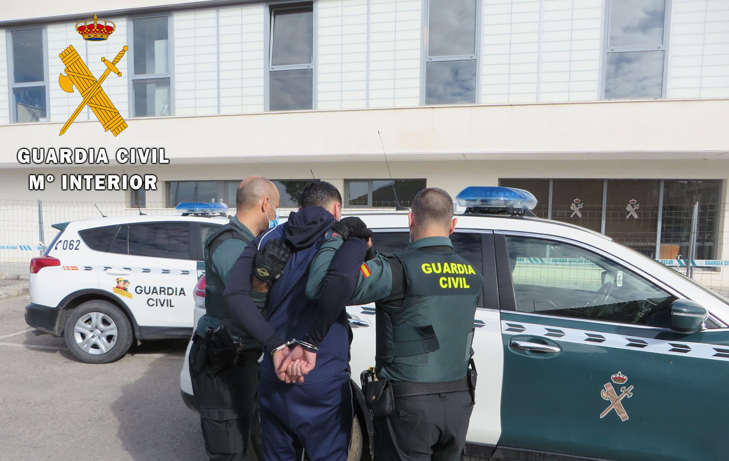 Uno de los detenidos es introducido en un coche de la Guardia Civil.