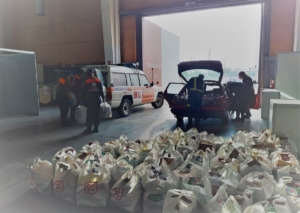 Voluntarios de protección civil preparan un reparto de comida.