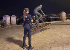 Imagen de una policía local de Toledo frente a la estatua de Bahamontes.