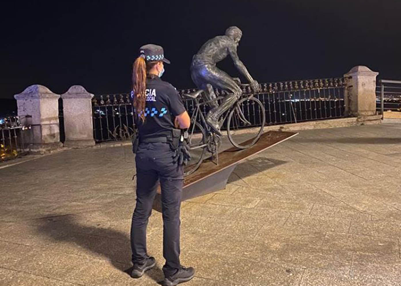 Imagen de una policía local de Toledo frente a la estatua de Bahamontes.