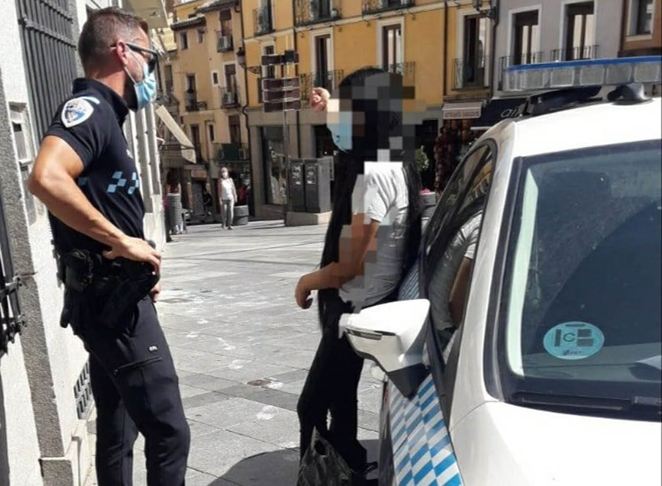 Un policía local de Toledo con la joven que habría cometido el robo. casco de toledo