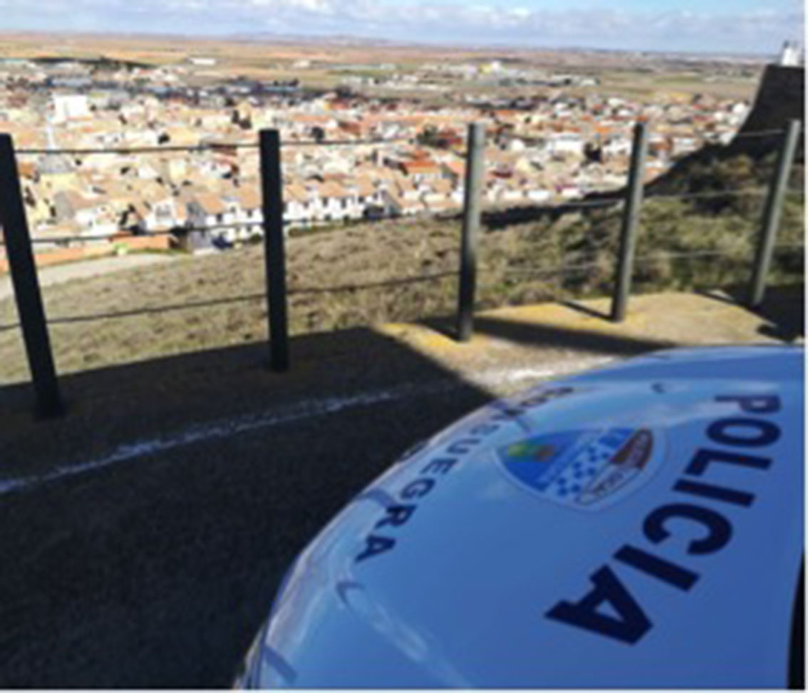 Imagen de archivo de un coche de la Policía Local de Consuegra, con la localidad toledana al fondo.