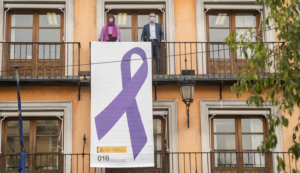 Consuelo García y Francho Tierraseca, en uno de los balcones de la Deegación del Gobierno, en Toledo, junto a un gran lazo contra la violencia machista.