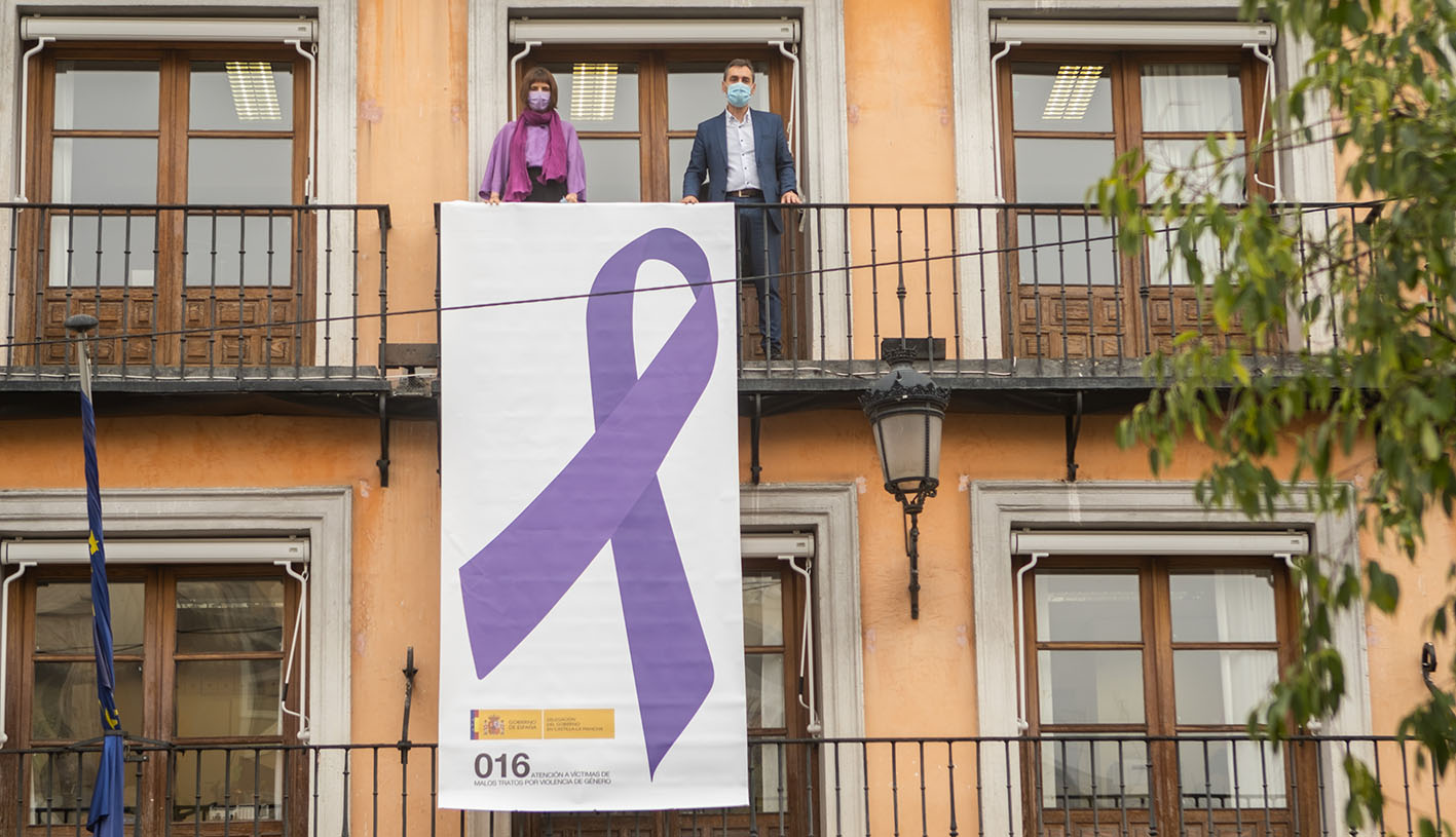 Consuelo García y Francho Tierraseca, en uno de los balcones de la Deegación del Gobierno, en Toledo, junto a un gran lazo contra la violencia machista.