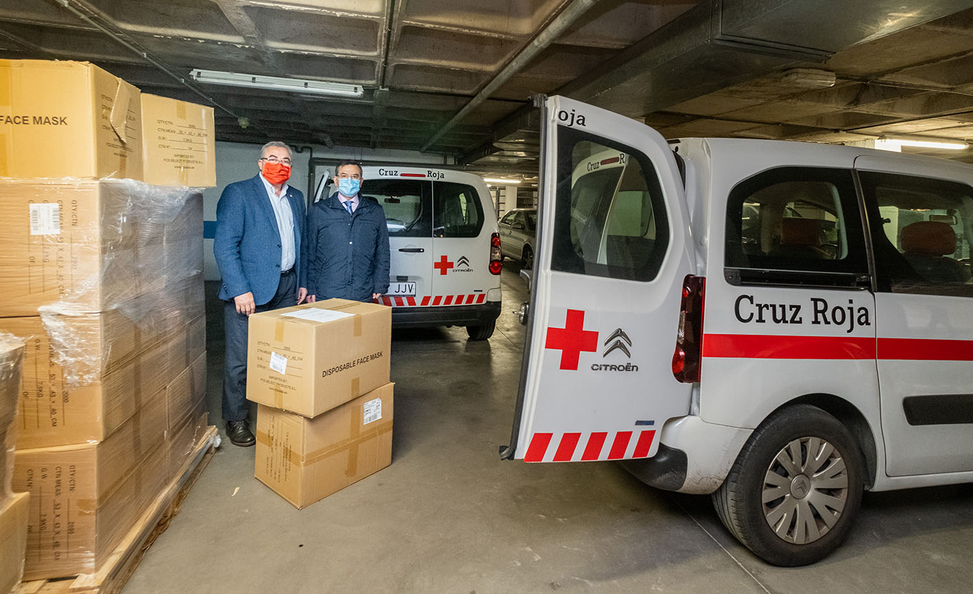 Carlos Ángel Devia, a la derecha, junto a uno de los responsables de Cruz Roja en Toledo, durante la entrega de mascarillas para los más vulnerables.