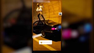 Imagen del joven sobre su coche bailando.