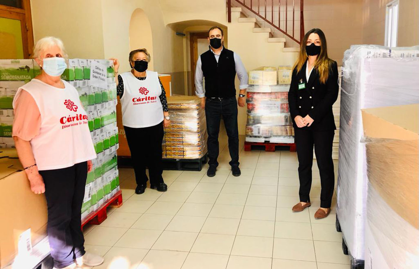 Miembros de Mercadona y voluntarias de Cáritas Quintanar, con parte de los alimentos no perecederos entregados.