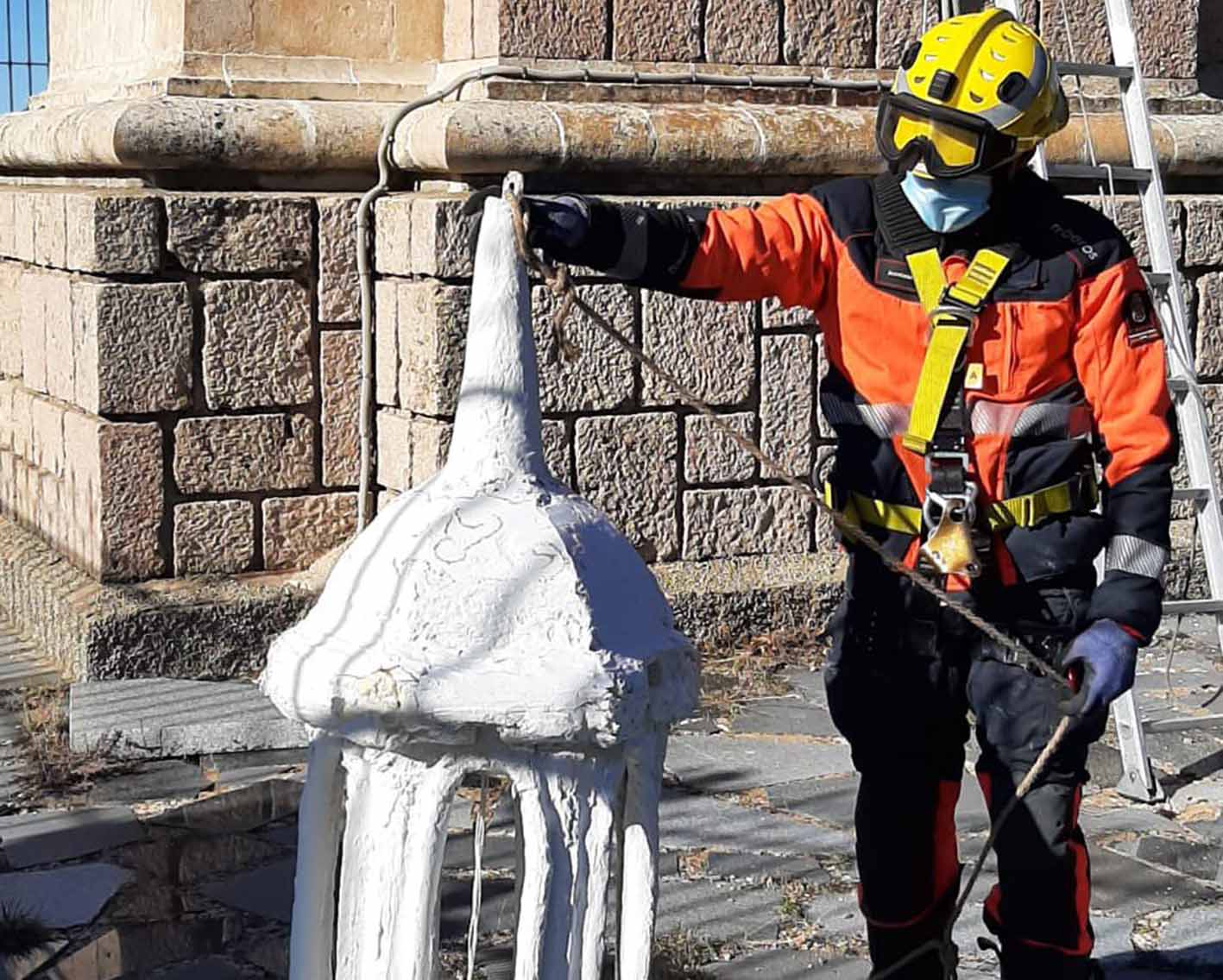 Se subieron al monumento para colocarle este farolillo blanco al monumento del Sagrado Corazón de Jesús.