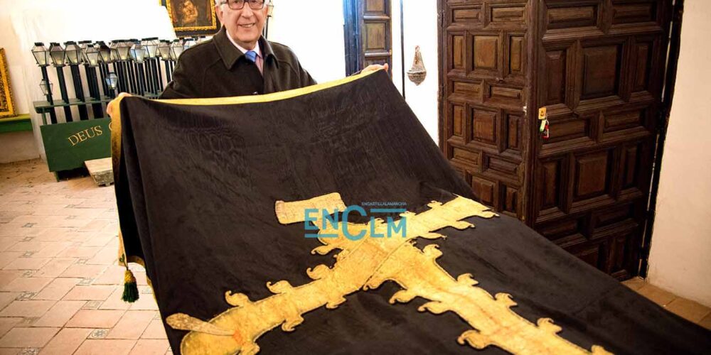 Fernando Lorenzana, hermano mayor de la cofradía, junto al Paño de la Caridad que data de hace dos siglos y que se conserva en muy buen estado. Aunque en la procesión sale otro más actual. Foto: Rebeca Arango.