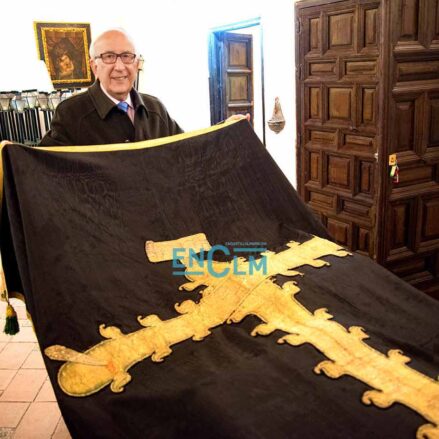 Fernando Lorenzana, hermano mayor de la cofradía, junto al Paño de la Caridad que data de hace dos siglos y que se conserva en muy buen estado. Aunque en la procesión sale otro más actual. Foto: Rebeca Arango.