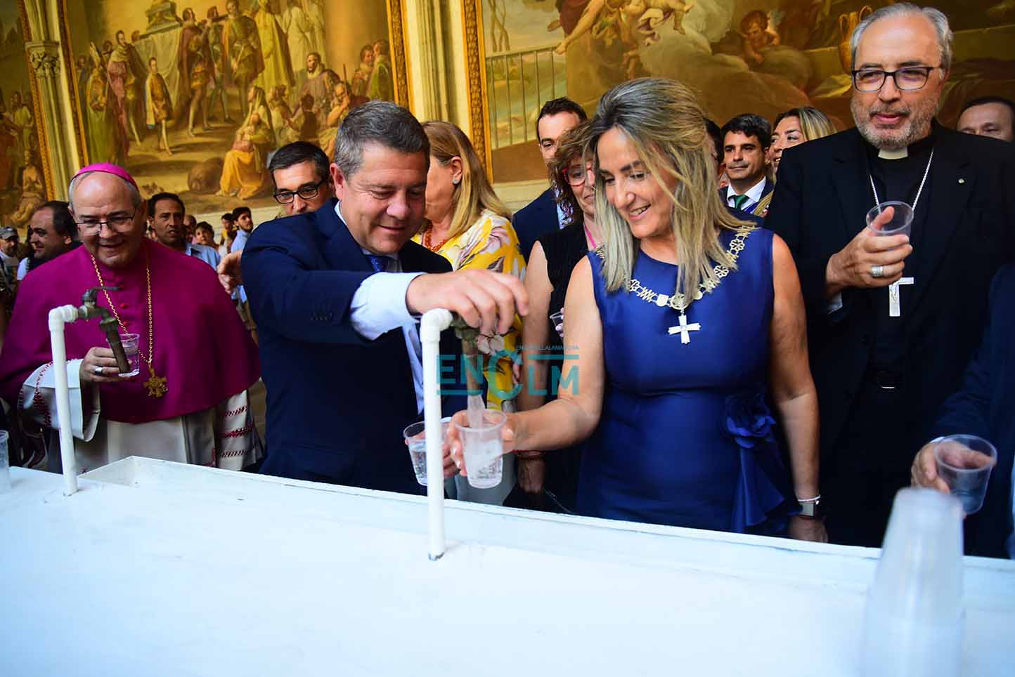 Page, junto a la alcaldesa de Toledo, Milagros Tolón, bebiendo el agua (no de los botijos y sí en vasos) en la Catedral de Toledo. Foto: Rebeca Arango.