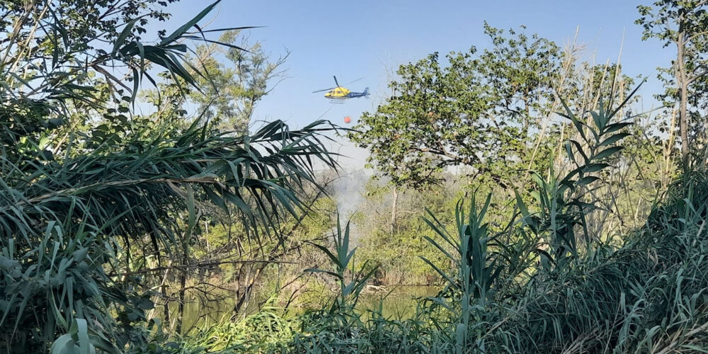 Un helicóptero suelta agua sobre la isla del Tajo en Toledo. Foto: Rebeca Arango.