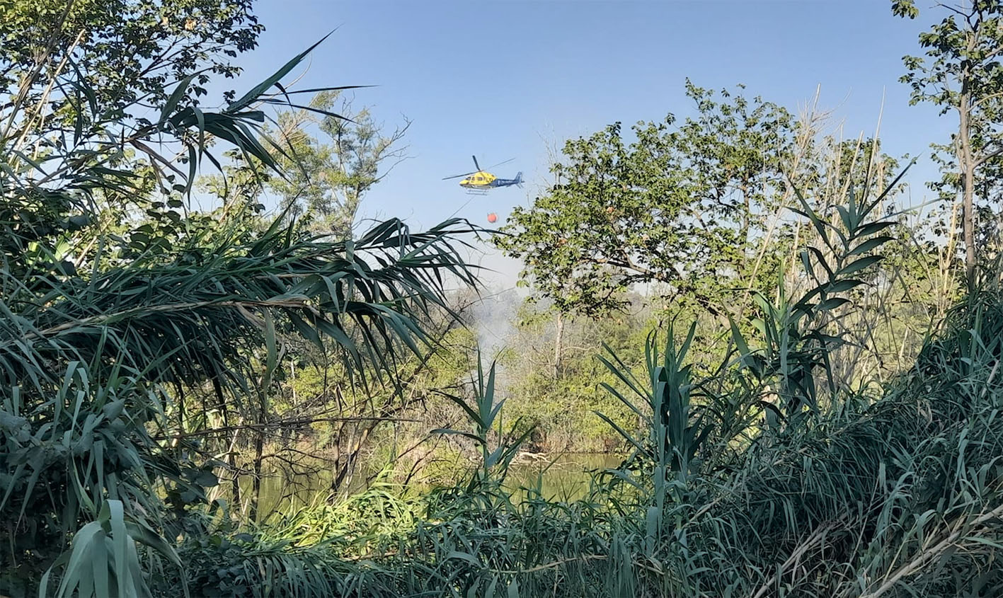 Un helicóptero suelta agua sobre la isla del Tajo en Toledo. Foto: Rebeca Arango.