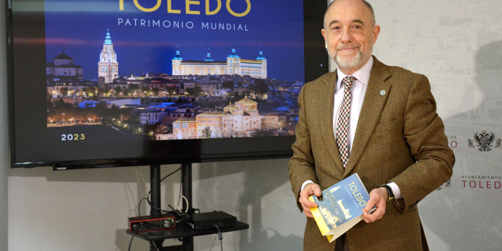 Paco Rueda, junto a la portada del calendario que ha elaborado el Ayuntamiento de Toledo para 2023.