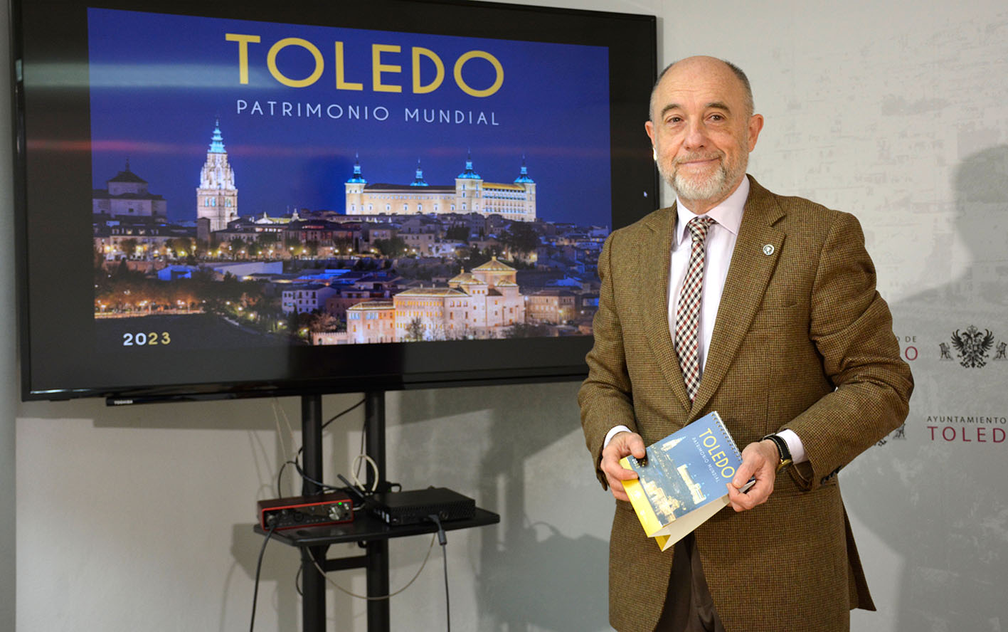 Paco Rueda, junto a la portada del calendario que ha elaborado el Ayuntamiento de Toledo para 2023.