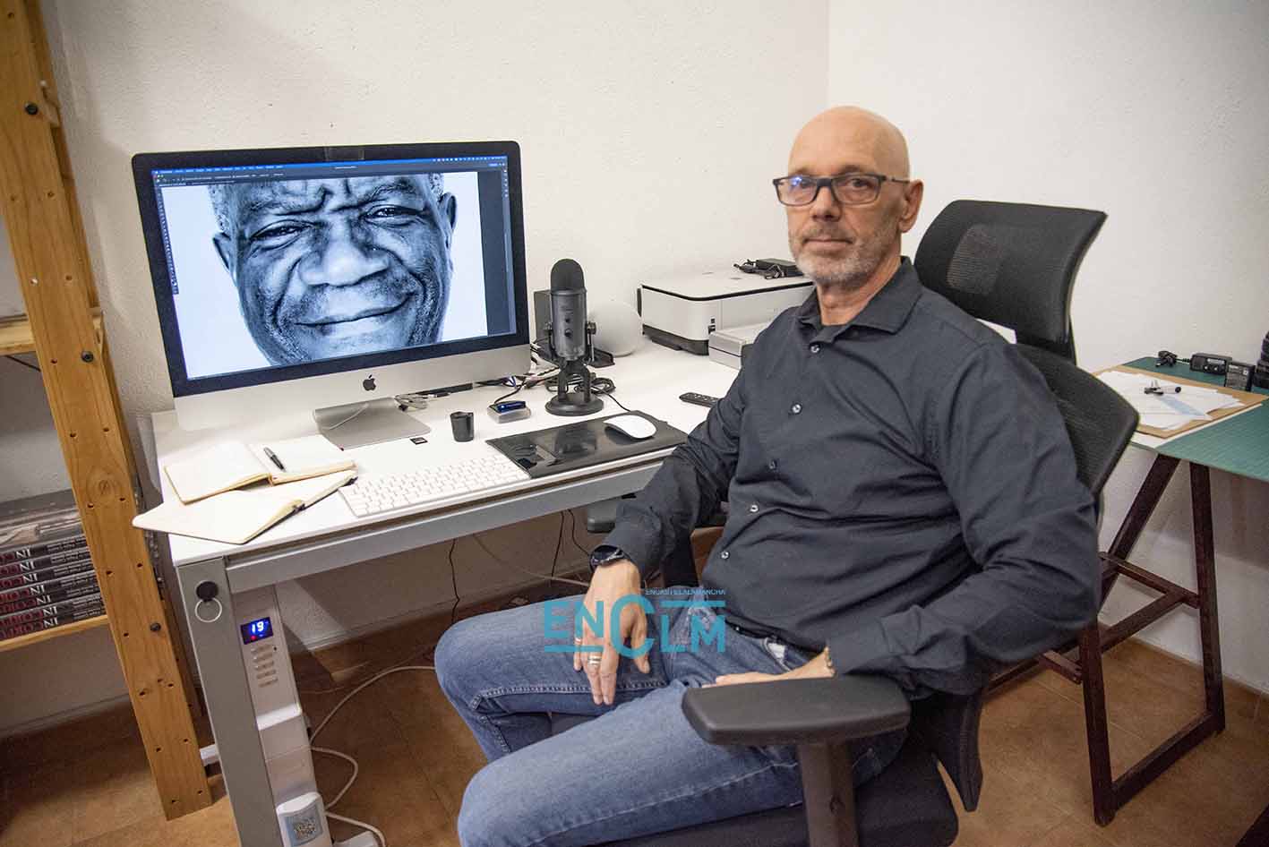 Pepe Castro, en su estudio. Detrás, en la pantalla del ordenador, una fotografía del doctor Denis Mukwege, Nobel de la Paz. Foto: Rebeca Arango.