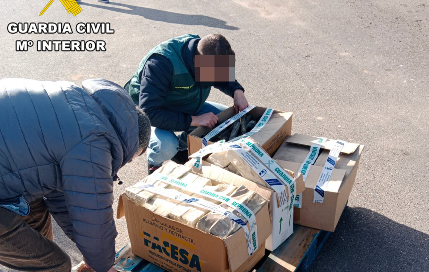 Agentes de la Guardia Civil junto a algunas de las botellas de vino "mal" etiquetadas.