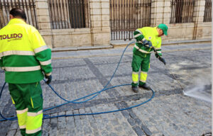 Trabajadores municipales, quitando la cera acumulada en las calles tras Semana Santa.