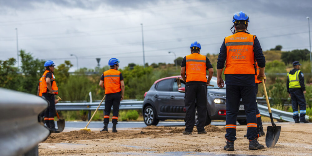 Miembros de Protección Civil traban limpiando una carretera cubierta de barro debido a las fuertes lluvias de la jornada de este domingo, en Toledo. EFE/ Ángeles Visdómine