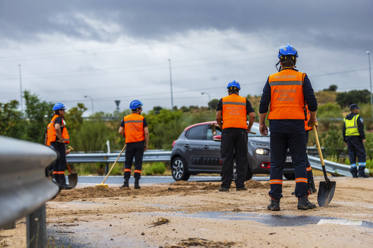 Miembros de Protección Civil traban limpiando una carretera cubierta de barro debido a las fuertes lluvias de la jornada de este domingo, en Toledo. EFE/ Ángeles Visdómine