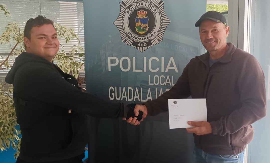 Momento en el que el joven que se ha encontrado los 2.000 euros se los entrega a su legítimo propietario. Foto: Policía Local de Ciudad Real.