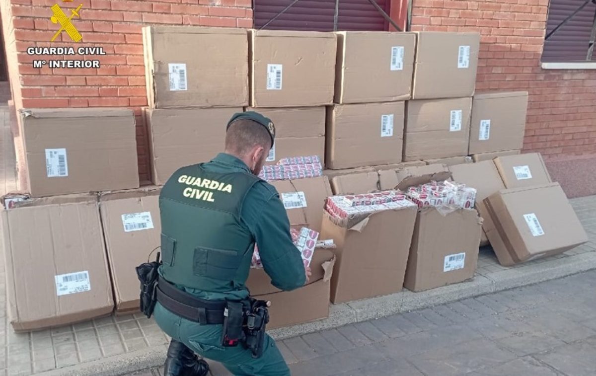 Un guardia civil, junto a las cajetillas requisadas.