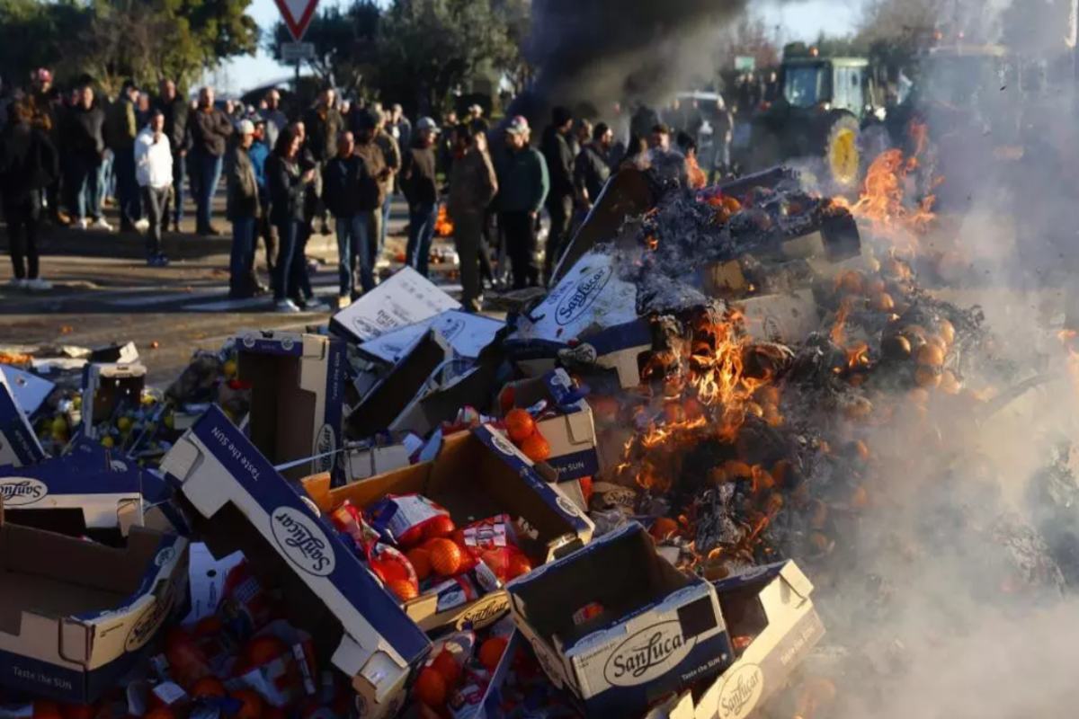 Imagen de agricultores franceses quemando frutas españolas durante una manifestación. EFE/EPA/GUILLAUME HORCAJUELO.