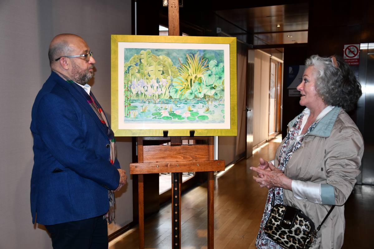 Tomás Arribas, presenciando la acuarela “Ribera 5”, de María Luisa Martín.