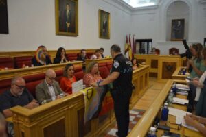 Imagen del momento en el que un Policía Local retira la bandera LGTBI colocada por el PSOE.