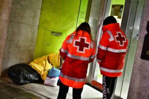 Imagen de archivo de dos voluntarios de Cruz Roja atendiendo a una persona sin hogar