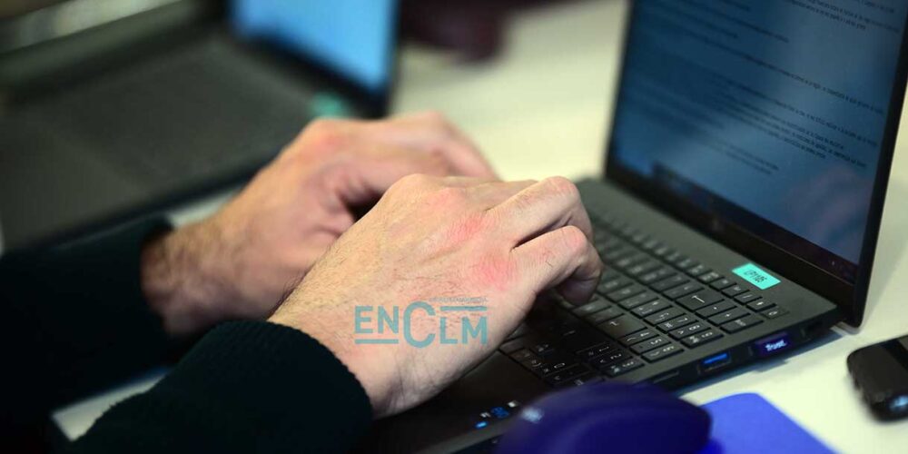 Periodista escribe en un ordenador durante una rueda de prensa, medios de comunicación