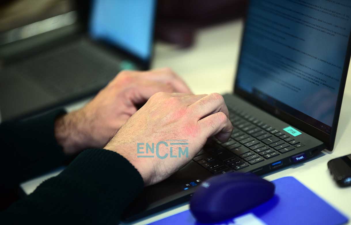 Periodista escribe en un ordenador durante una rueda de prensa, medios de comunicación