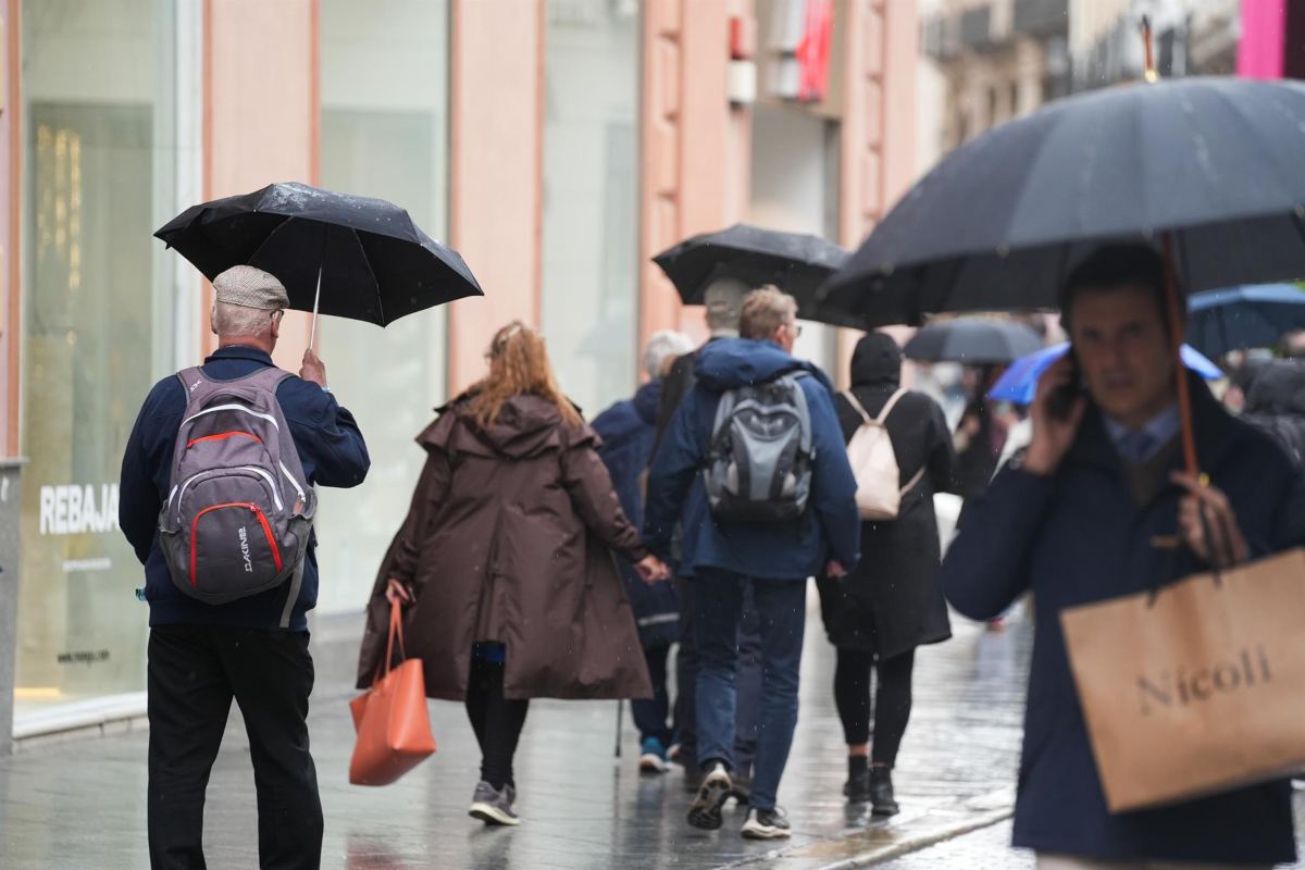 Viandantes protegiéndose de la lluvia.