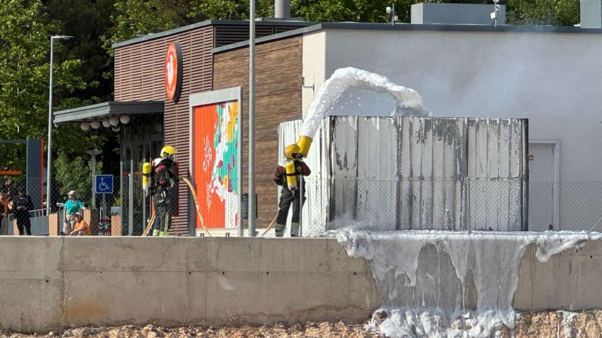 Los bomberos trabajando en la extinción del contenedor