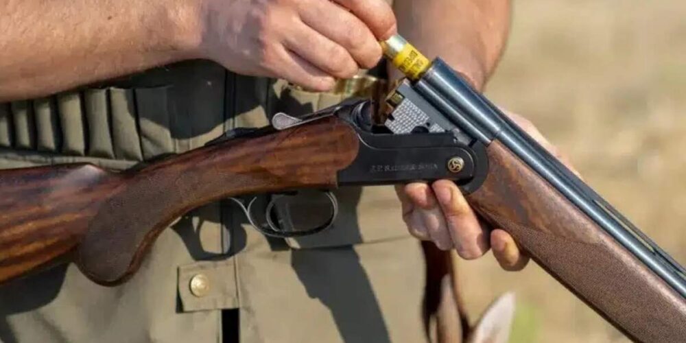 Imagen de archivo de un cazador cargando su escopeta