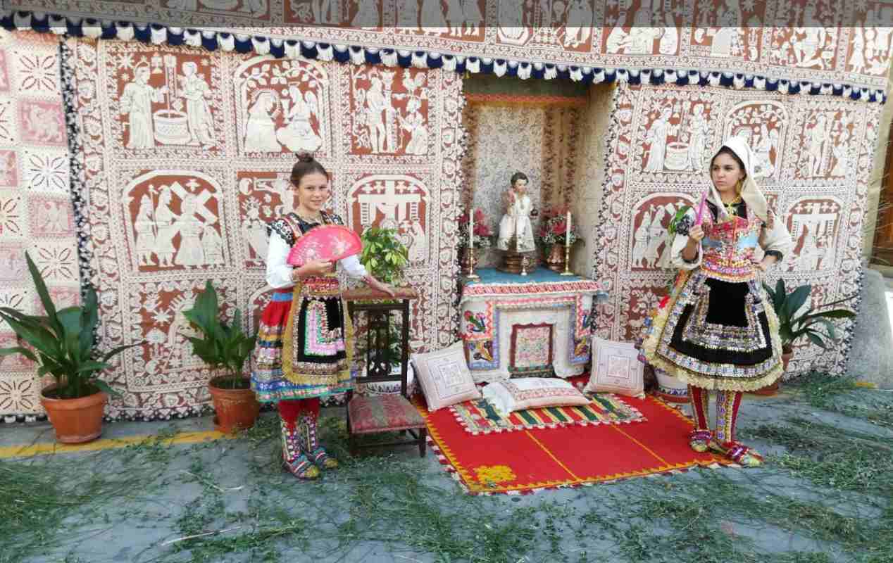 Dos niñas vestidas de lagarteranas al frente de un altar. Foto: Ayuntamiento de Lagartera.