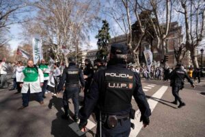 Varias personas se enfrentan a agentes de la Policía durante una concentración de los sindicatos médicos frente al Ministerio de Sanidad.