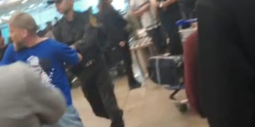 Un agente de policía agarrando a un hombre en el aeropuerto de El Cairo (Egipto). Foto: plataforma Toledo por Palestina